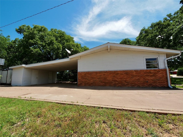 1431 Brazos St, Graham, TX 76450 - view of side of property with brick siding, driveway, and an attached carport