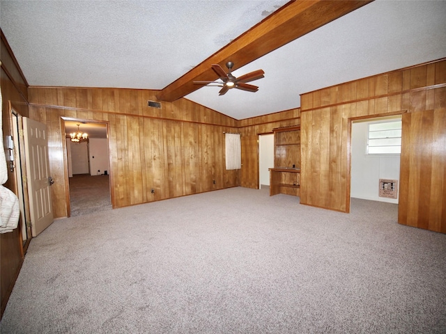 1431 Brazos St, Graham, TX 76450 - unfurnished room featuring a chandelier, a ceiling fan, wood walls, carpet flooring, and a textured ceiling