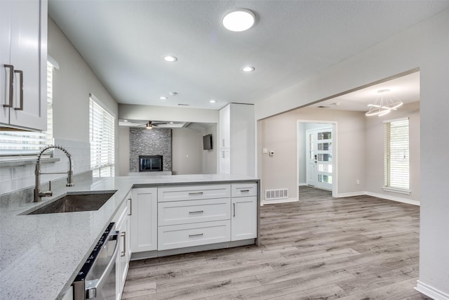 15820 Meadow Vista Dr, Dallas, TX 75248 - kitchen with a sink, light stone counters, light wood finished floors, white cabinetry, and recessed lighting