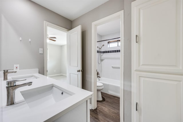 15820 Meadow Vista Dr, Dallas, TX 75248 - bathroom featuring toilet, double vanity, wood finished floors, bathtub / shower combination, and a ceiling fan