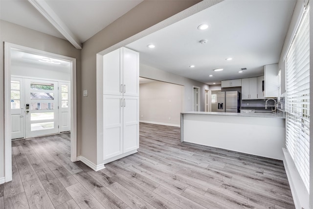 15820 Meadow Vista Dr, Dallas, TX 75248 - kitchen with stainless steel fridge with ice dispenser, a sink, light wood-style floors, white cabinetry, and baseboards