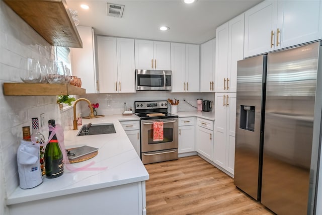 3311 Blackburn St Unit 115, Dallas, TX 75204 - kitchen with stainless steel appliances, a sink, recessed lighting, white cabinetry, and backsplash
