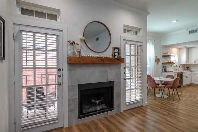 3311 Blackburn St Unit 115, Dallas, TX 75204 - living area featuring crown molding, a tile fireplace, light wood-style floors, and recessed lighting