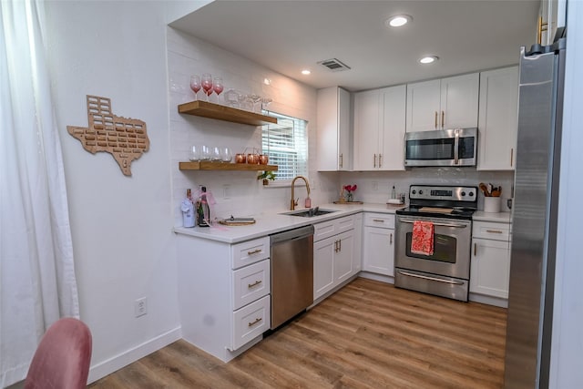 3311 Blackburn St Unit 115, Dallas, TX 75204 - kitchen with appliances with stainless steel finishes, a sink, white cabinetry, backsplash, and light countertops