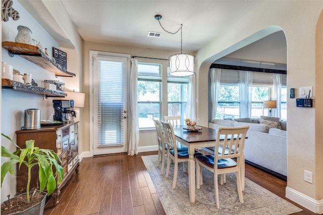 1386 Caspian Dr, Roanoke, TX 76262 - dining space featuring arched walkways, plenty of natural light, baseboards, and dark wood-type flooring