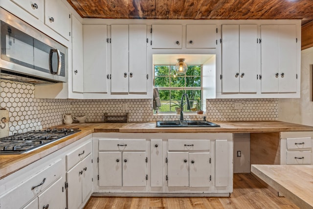 40248 Fm 2481, Hico, TX 76457 - kitchen featuring stainless steel appliances, wood ceiling, white cabinets, a sink, and light wood-style floors