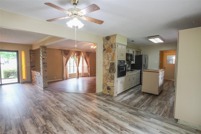 107 Clover Dr, Gun Barrel City, TX 75156 - kitchen with black appliances, open floor plan, wood finished floors, ceiling fan, and cream cabinets