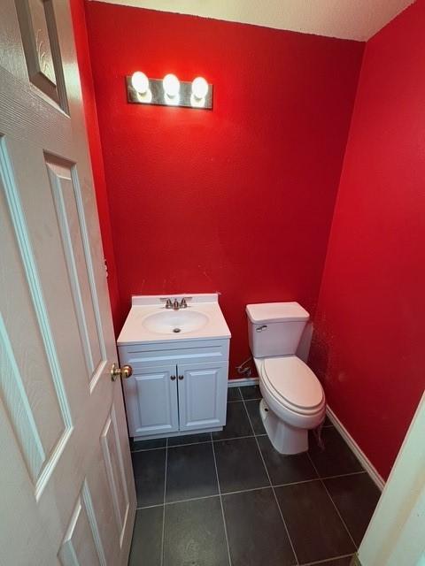 5421 Palace Dr, Richardson, TX 75082 - half bathroom with toilet, vanity, tile patterned floors, and baseboards