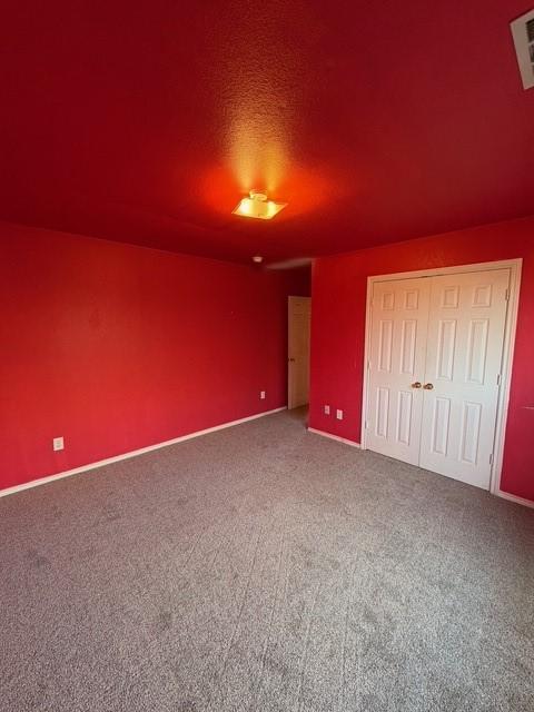 5421 Palace Dr, Richardson, TX 75082 - unfurnished bedroom featuring carpet floors, a closet, and baseboards