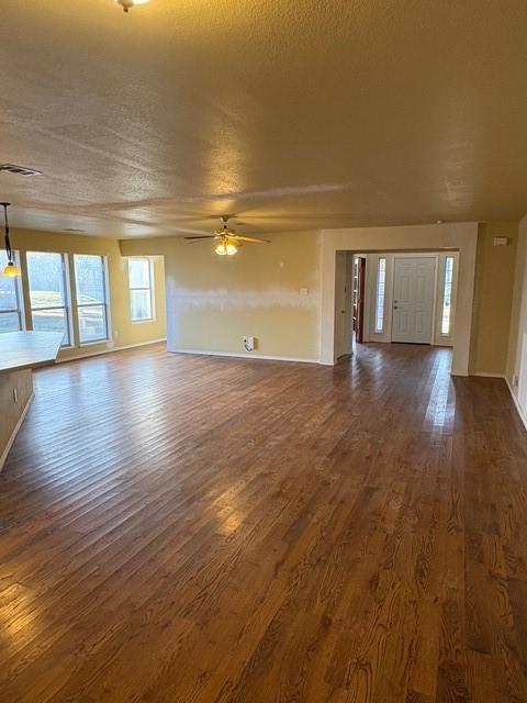 5421 Palace Dr, Richardson, TX 75082 - unfurnished living room with dark wood-style floors, ceiling fan, and baseboards