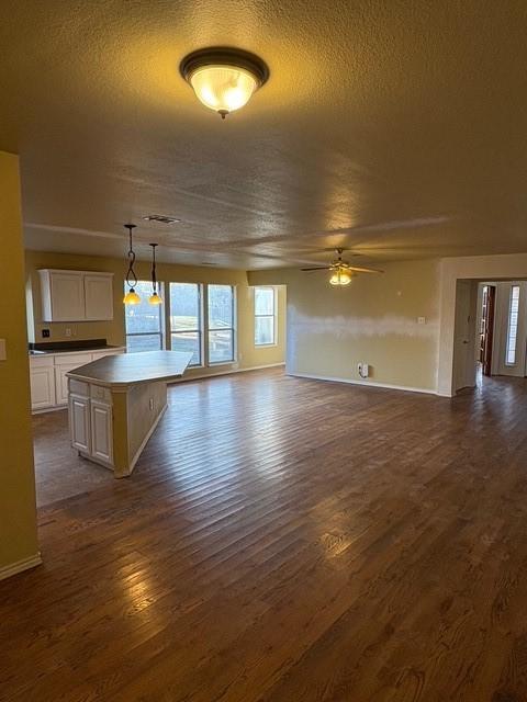 5421 Palace Dr, Richardson, TX 75082 - unfurnished living room with a ceiling fan, dark wood finished floors, a textured ceiling, and baseboards