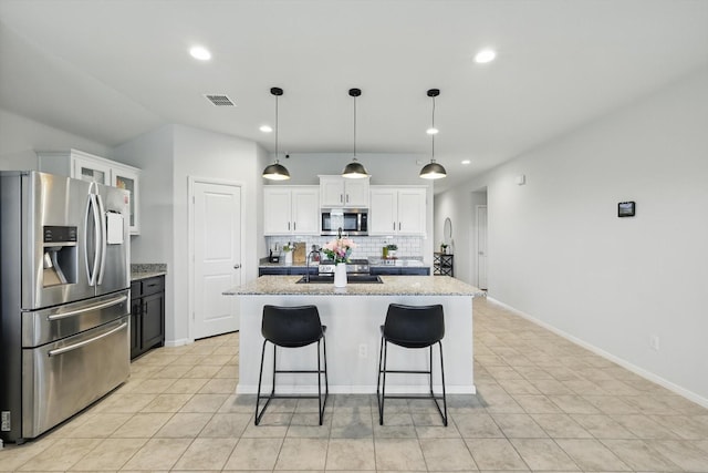 3800 Canyon Verde Ln, Denton, TX 76226 - kitchen featuring appliances with stainless steel finishes, tasteful backsplash, recessed lighting, white cabinetry, and a center island with sink