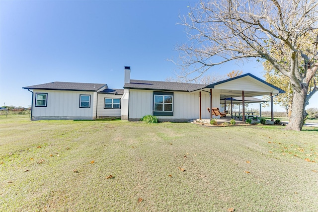 430 Hornik Rd, Ennis, TX 75119 - back of house featuring a chimney, a yard, and board and batten siding