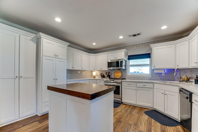 430 Hornik Rd, Ennis, TX 75119 - kitchen with appliances with stainless steel finishes, a sink, butcher block countertops, white cabinetry, and recessed lighting