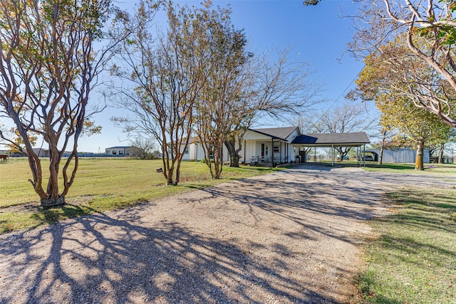430 Hornik Rd, Ennis, TX 75119 - view of front facade with a carport, driveway, a front lawn, and board and batten siding