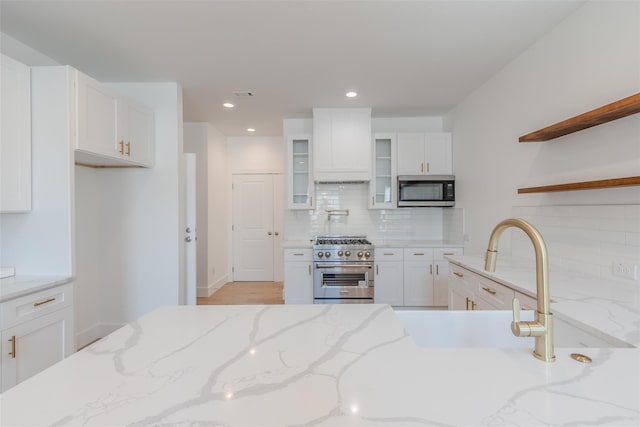 702 Graham Ave, Dallas, TX 75223 - kitchen featuring appliances with stainless steel finishes, white cabinets, backsplash, glass insert cabinets, and open shelves