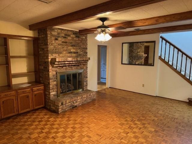 401 Locust St, Shreveport, LA 71105 - unfurnished living room featuring a brick fireplace, a ceiling fan, beam ceiling, and stairway