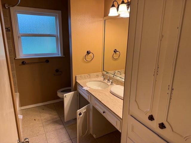 401 Locust St, Shreveport, LA 71105 - bathroom with vanity, toilet, tile patterned flooring, and baseboards