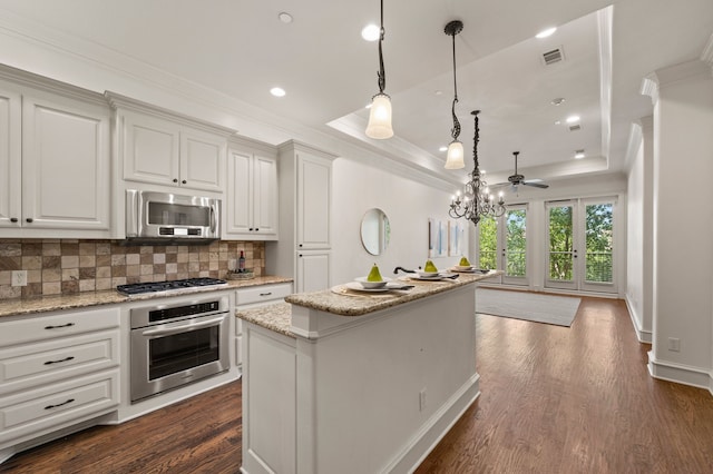 33 Main St Unit 220, Colleyville, TX 76034 - kitchen with appliances with stainless steel finishes, decorative backsplash, crown molding, dark wood-style flooring, and a center island