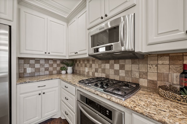 33 Main St Unit 220, Colleyville, TX 76034 - kitchen with appliances with stainless steel finishes, white cabinetry, decorative backsplash, and light stone counters