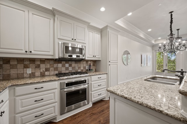 33 Main St Unit 220, Colleyville, TX 76034 - kitchen featuring appliances with stainless steel finishes, a sink, dark wood-type flooring, tasteful backsplash, and a chandelier