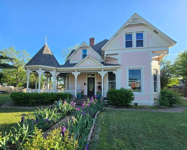 306 E Tarrant St, Bowie, TX 76230 - victorian home featuring a porch, a front yard, and a chimney