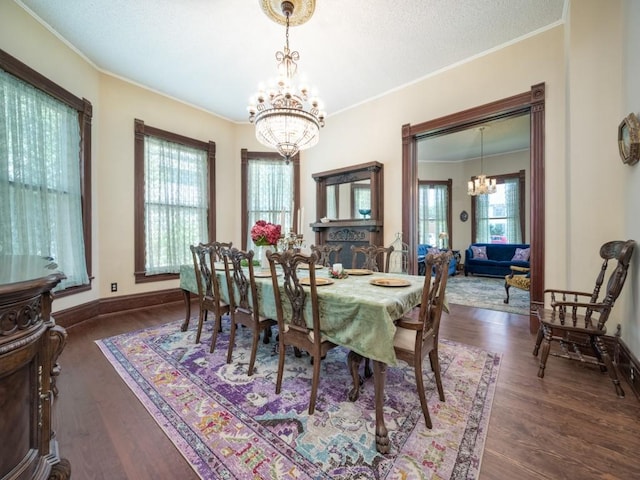 306 E Tarrant St, Bowie, TX 76230 - dining space with a chandelier, ornamental molding, wood finished floors, and baseboards