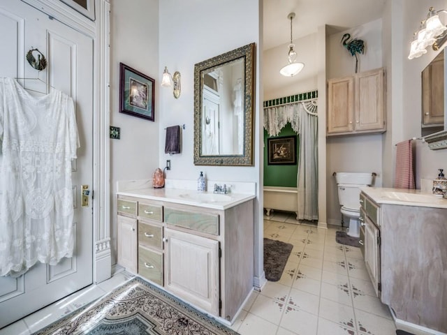 306 E Tarrant St, Bowie, TX 76230 - bathroom with two vanities, toilet, and tile patterned floors