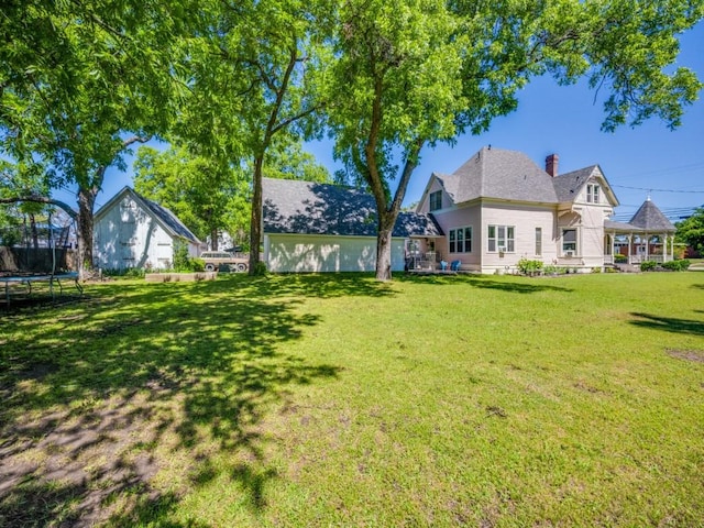 306 E Tarrant St, Bowie, TX 76230 - view of grassy yard with a trampoline