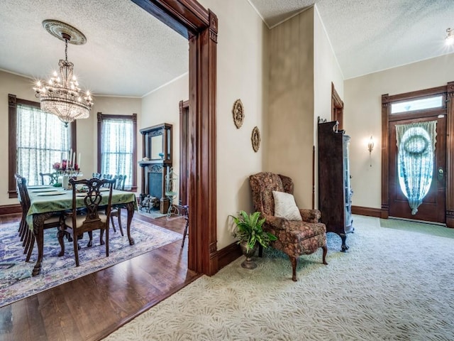 306 E Tarrant St, Bowie, TX 76230 - entrance foyer featuring a textured ceiling, a chandelier, baseboards, crown molding, and wood finished floors
