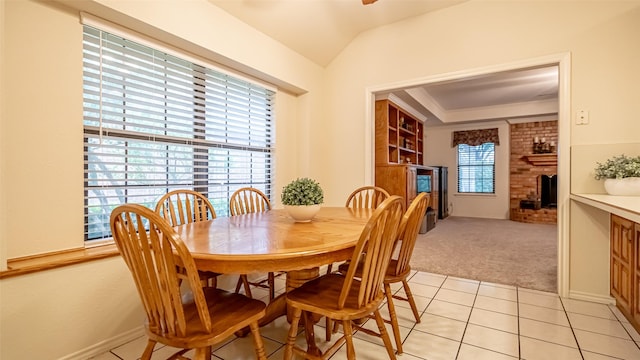 137 Sunny Meadows Dr, Burleson, TX 76028 - dining room featuring light colored carpet, a brick fireplace, light tile patterned flooring, lofted ceiling, and a ceiling fan