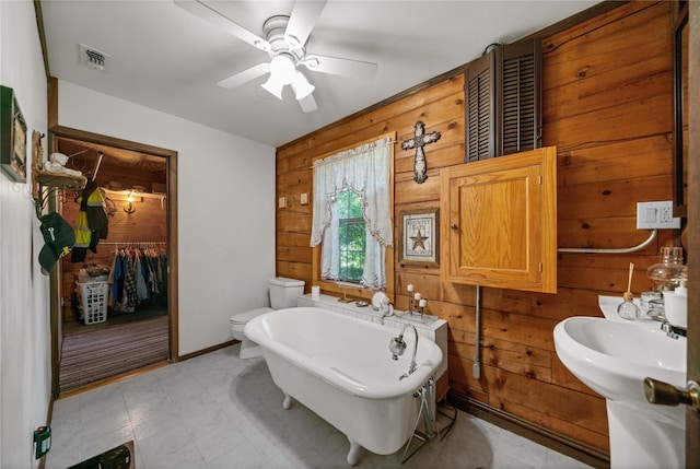 225 Springwood Cir, Chandler, TX 75758 - full bathroom featuring wood walls, a freestanding tub, ceiling fan, a closet, and toilet