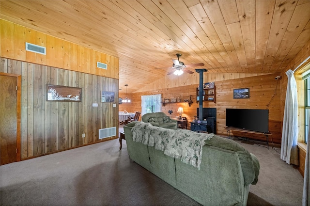 225 Springwood Cir, Chandler, TX 75758 - living area with wood walls, wooden ceiling, carpet, a wood stove, and plenty of natural light