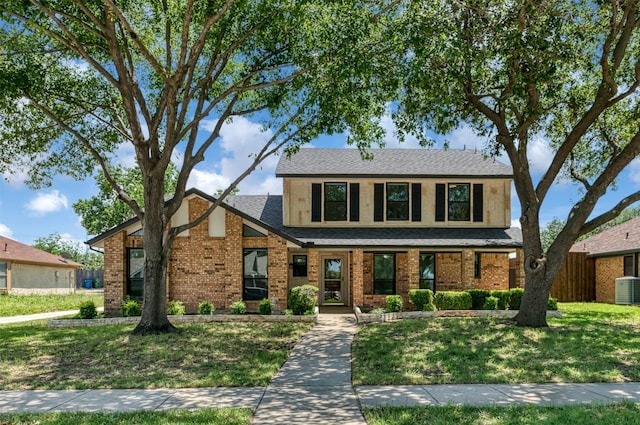 1606 Clarendon Dr, Lewisville, TX 75067 - traditional-style house with a front lawn, brick siding, a porch, and a shingled roof
