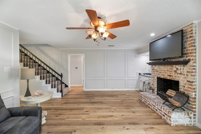 1606 Clarendon Dr, Lewisville, TX 75067 - living area with a ceiling fan, a decorative wall, wood finished floors, a textured ceiling, and stairs