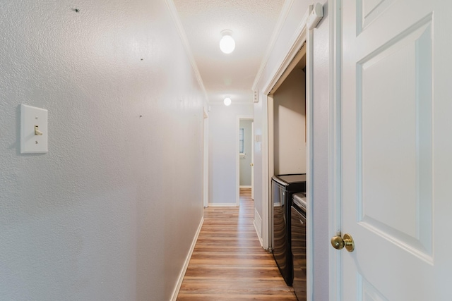 1103 Bluebonnet Hill Dr, Ennis, TX 75119 - corridor featuring washing machine and dryer, light wood finished floors, and ornamental molding