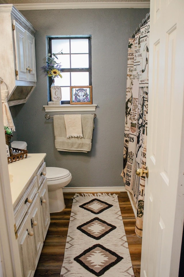 1103 Bluebonnet Hill Dr, Ennis, TX 75119 - full bath with vanity, wood finished floors, toilet, ornamental molding, and baseboards