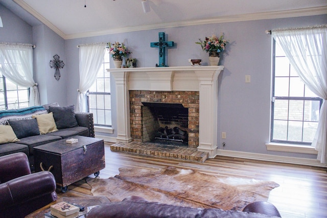 1103 Bluebonnet Hill Dr, Ennis, TX 75119 - living room featuring healthy amount of natural light, wood finished floors, a brick fireplace, lofted ceiling, and ornamental molding