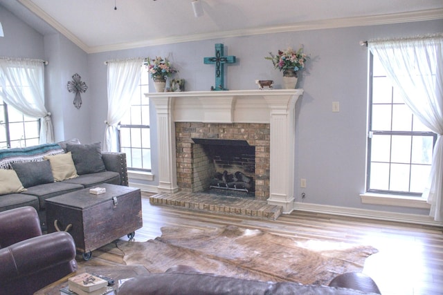 1103 Bluebonnet Hill Dr, Ennis, TX 75119 - living area with plenty of natural light, wood finished floors, a brick fireplace, vaulted ceiling, and crown molding