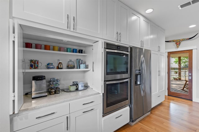 5120 Fairway Cir, Granbury, TX 76049 - kitchen featuring appliances with stainless steel finishes, light wood-style flooring, recessed lighting, white cabinetry, and light stone countertops