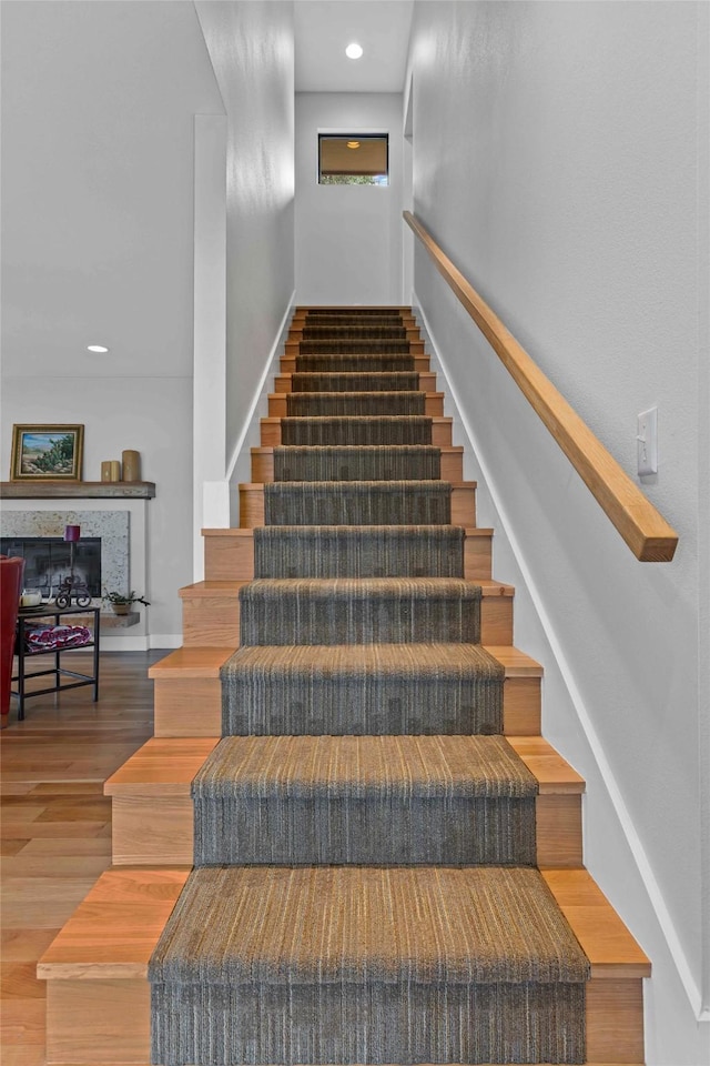5120 Fairway Cir, Granbury, TX 76049 - stairs featuring wood finished floors, baseboards, recessed lighting, and a fireplace with raised hearth