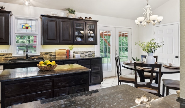 1000 Ballard Rd, Van Alstyne, TX 75495 - kitchen featuring a sink, light tile patterned floors, dark stone countertops, a chandelier, and hanging light fixtures