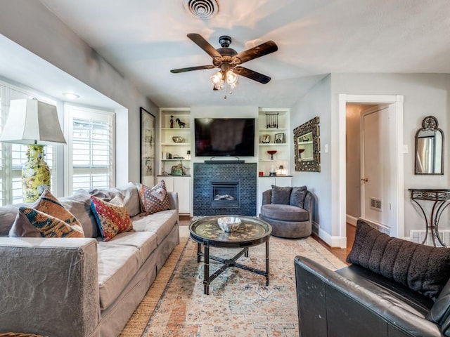 879 Peavy Rd, Dallas, TX 75218 - living area with a ceiling fan, a tiled fireplace, and baseboards