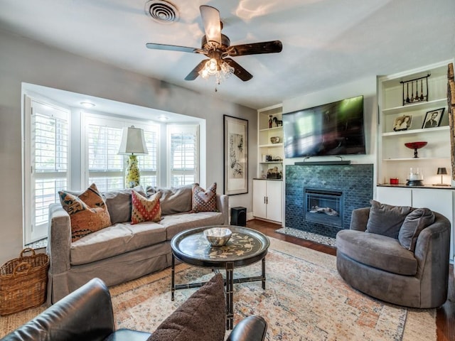 879 Peavy Rd, Dallas, TX 75218 - living area with a ceiling fan, plenty of natural light, a tile fireplace, and wood finished floors