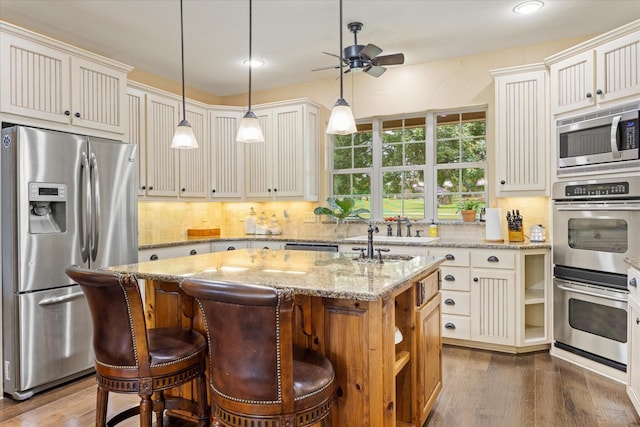 1096 Black Hawk Trl, Nemo, TX 76070 - kitchen featuring stainless steel appliances, a sink, ceiling fan, an island with sink, and backsplash