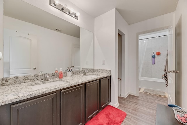 2211 Barrow St, Princeton, TX 75407 - full bathroom featuring double vanity, wood finished floors, shower / bath combo with shower curtain, and baseboards