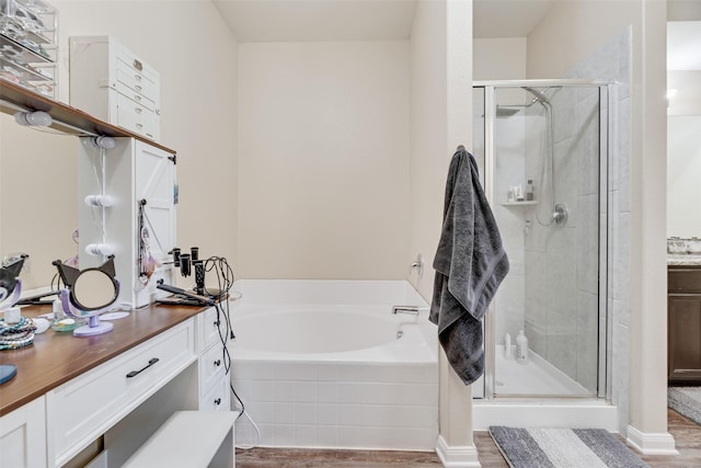2211 Barrow St, Princeton, TX 75407 - full bathroom with vanity, wood finished floors, a bath, and a stall shower