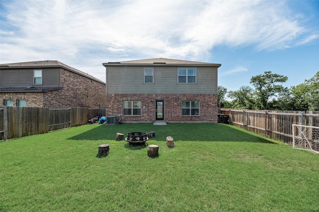2211 Barrow St, Princeton, TX 75407 - back of property featuring cooling unit, brick siding, and a fire pit