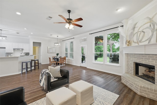 1137 Countryhill Dr, Keller, TX 76248 - living area featuring a ceiling fan, crown molding, a brick fireplace, dark wood-style flooring, and recessed lighting