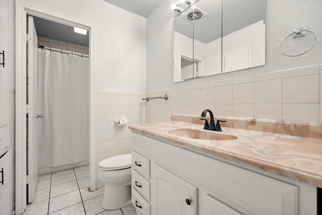 3249 Sandefer St, Abilene, TX 79603 - full bathroom with vanity, tile patterned flooring, toilet, tile walls, and a shower with curtain